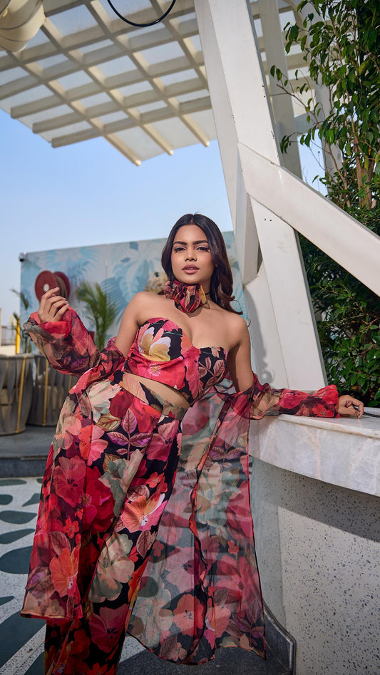 Woman in a colorful floral dress standing on a rooftop with a clear sky.