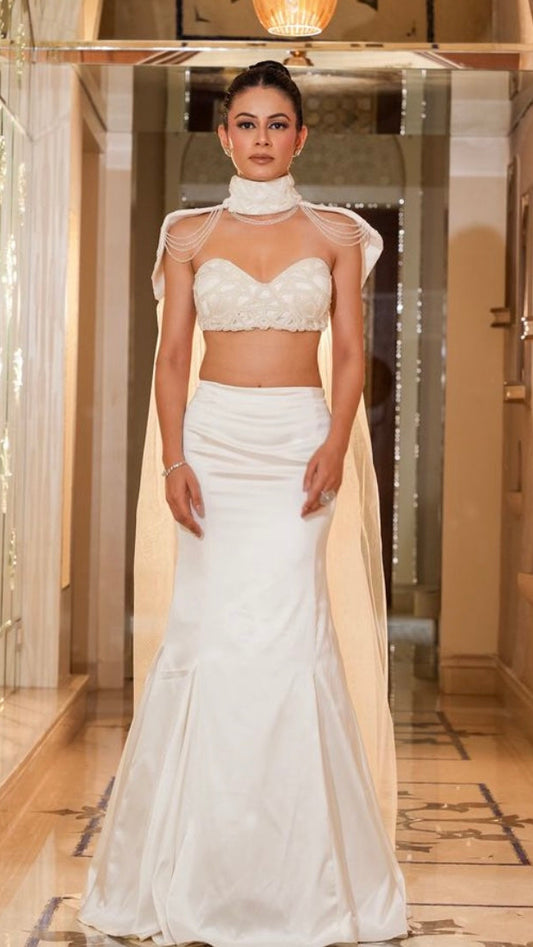 Woman in a white dress standing in an elegant interior setting