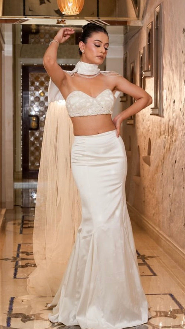 Woman in a white saree with a matching blouse in an indoor setting